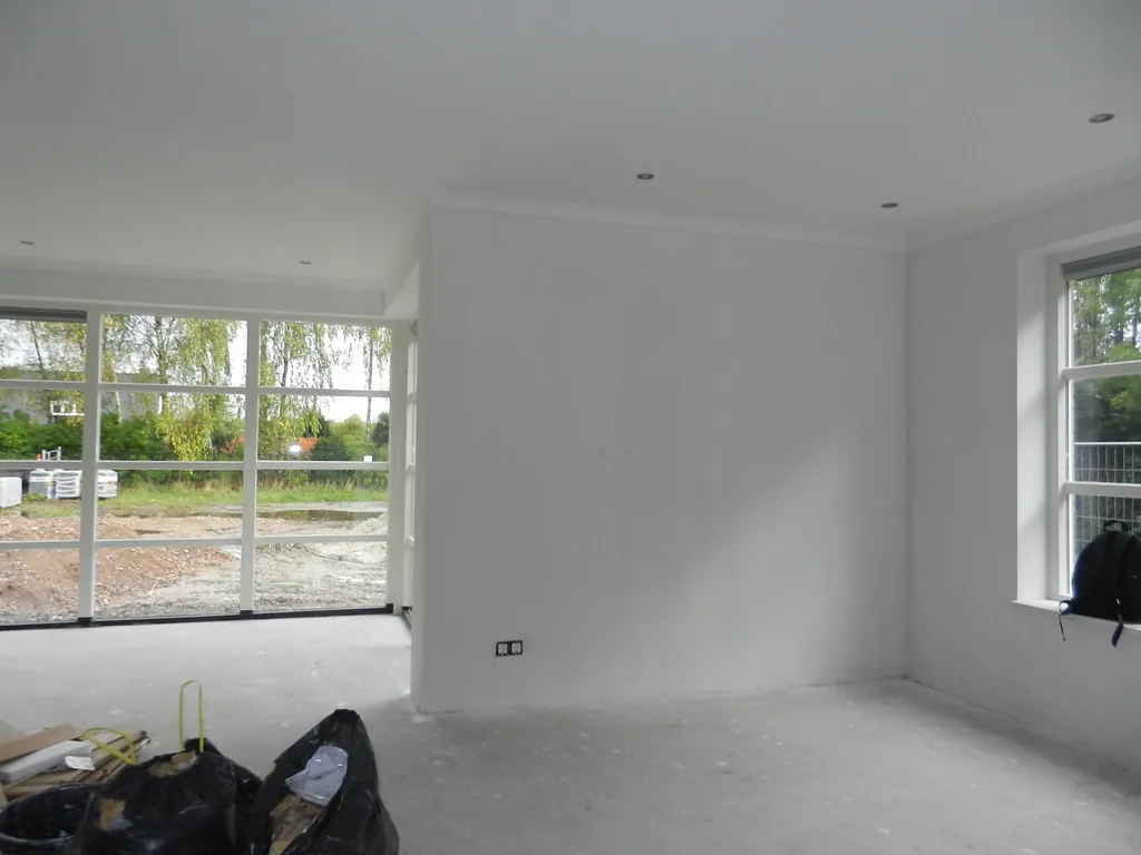 Woonkamer in een nieuwbouwwoning strak afgewerkt met dunpleister