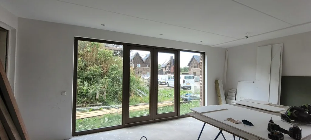 Nieuwbouwkamer met egaal gladde wanden en plafond na het aanbrengen van dunpleister